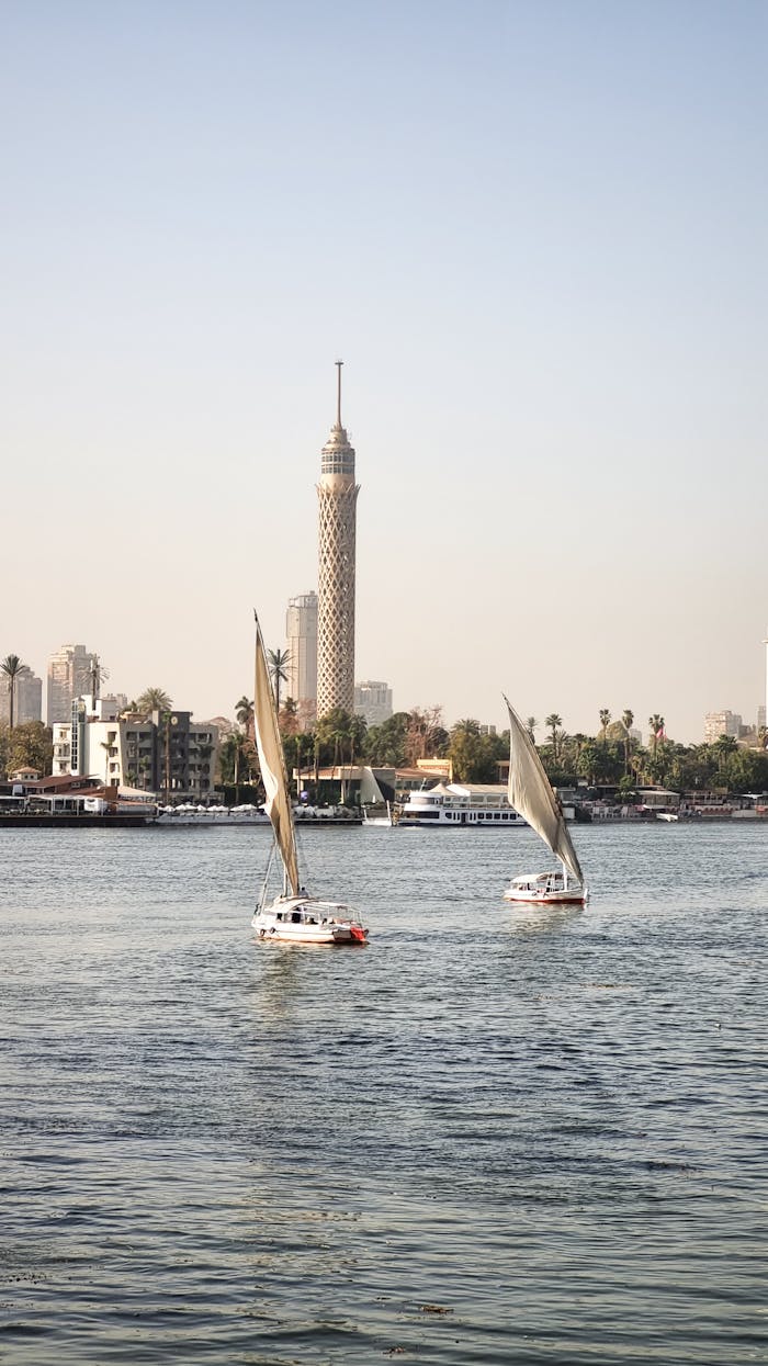 A picturesque scene of sailboats on the Nile with the iconic Cairo Tower in the background.