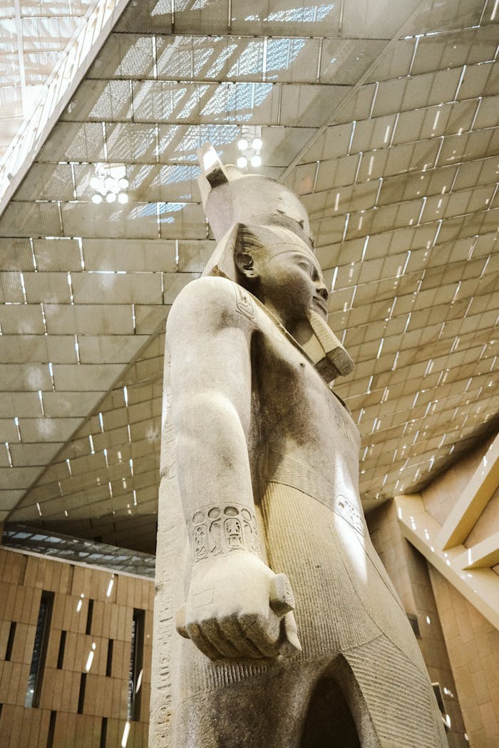 Side view of a colossal pharaoh statue inside Cairo's Grand Egyptian Museum.
