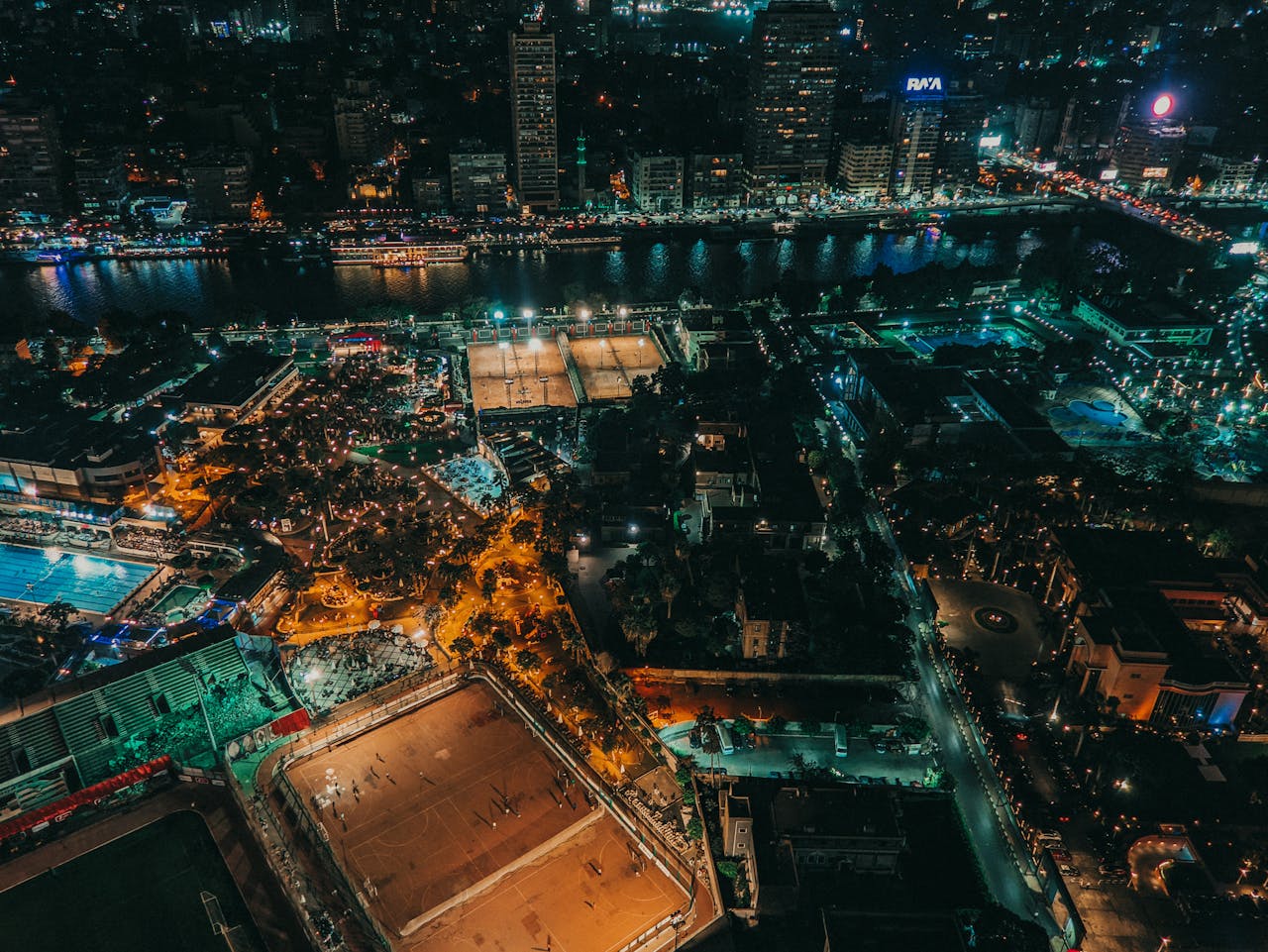 A captivating aerial night view of a lit-up cityscape by the river enhancing the urban skyline.